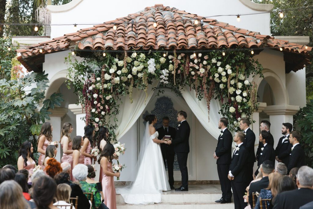 Popular Wedding Florals of 2025 - Multi-colored hanging amaranthus used in Ranchos Las Lomas ceremony. Florals by The Bloom of Time.
